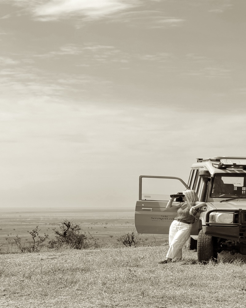 Laura Ferati with binoculars before the Serengeti plains