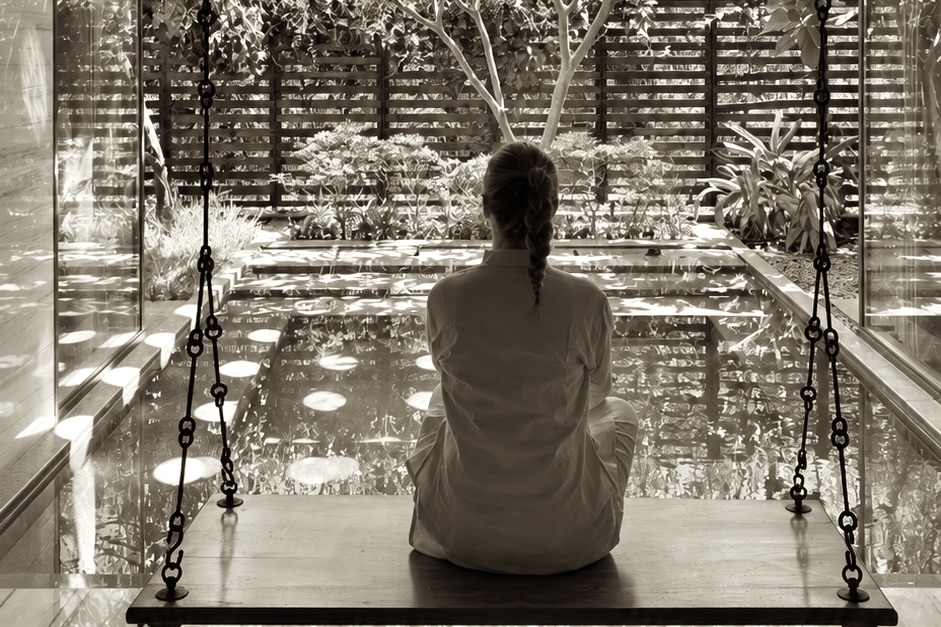Meditation on the swing seat above the pool, India
